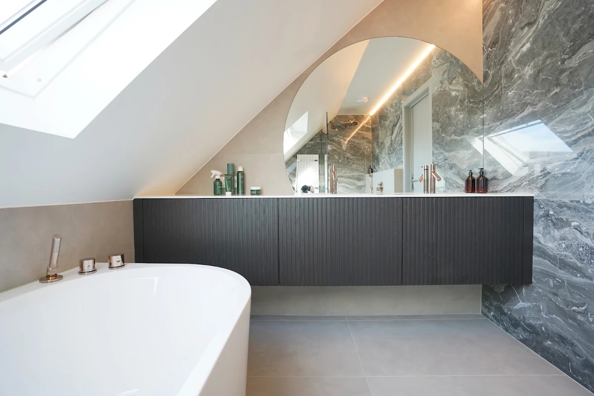 Badkamer met marmeren wand en donker ribbelmeubel